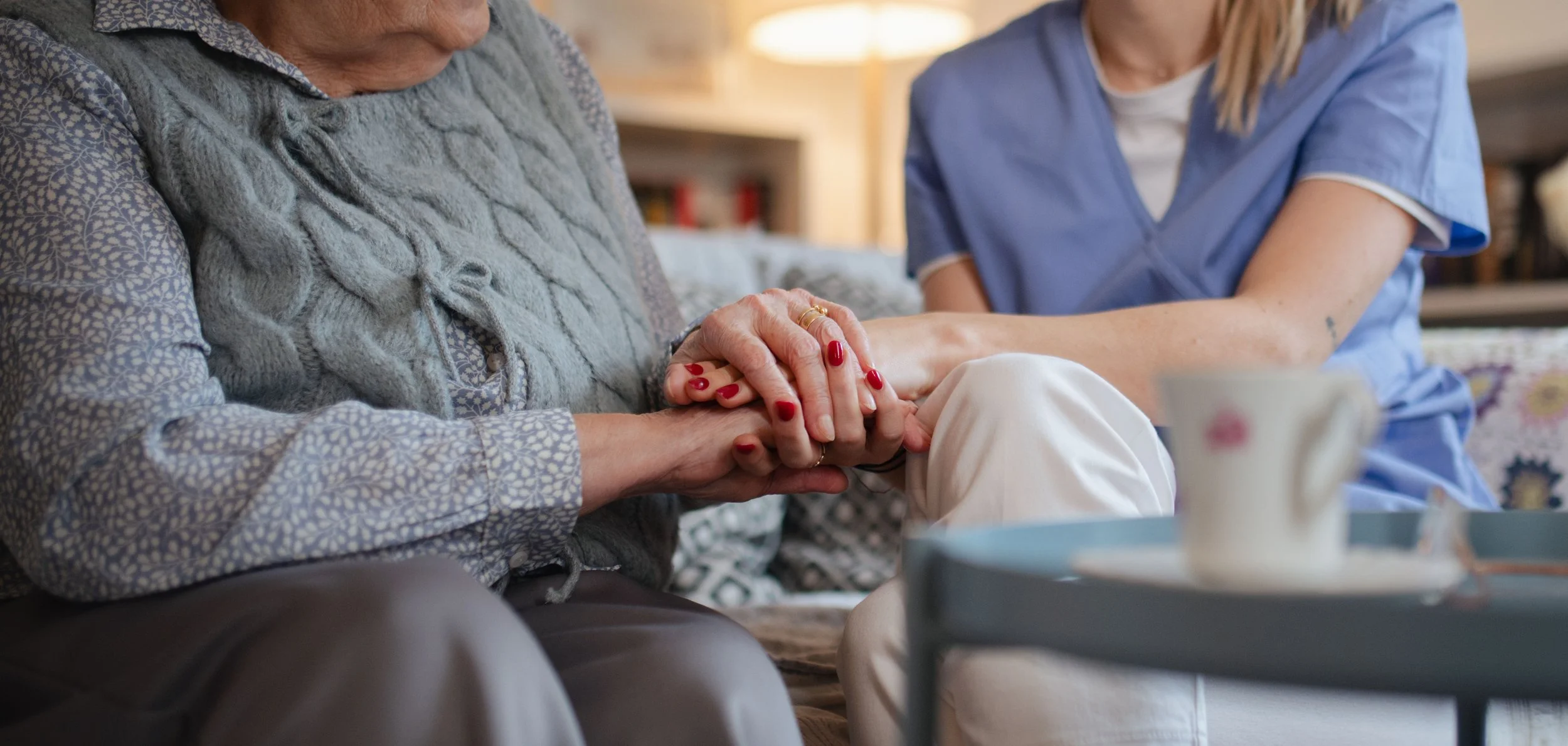 Caregiver holding an older adult's hands while providing comfort and support.