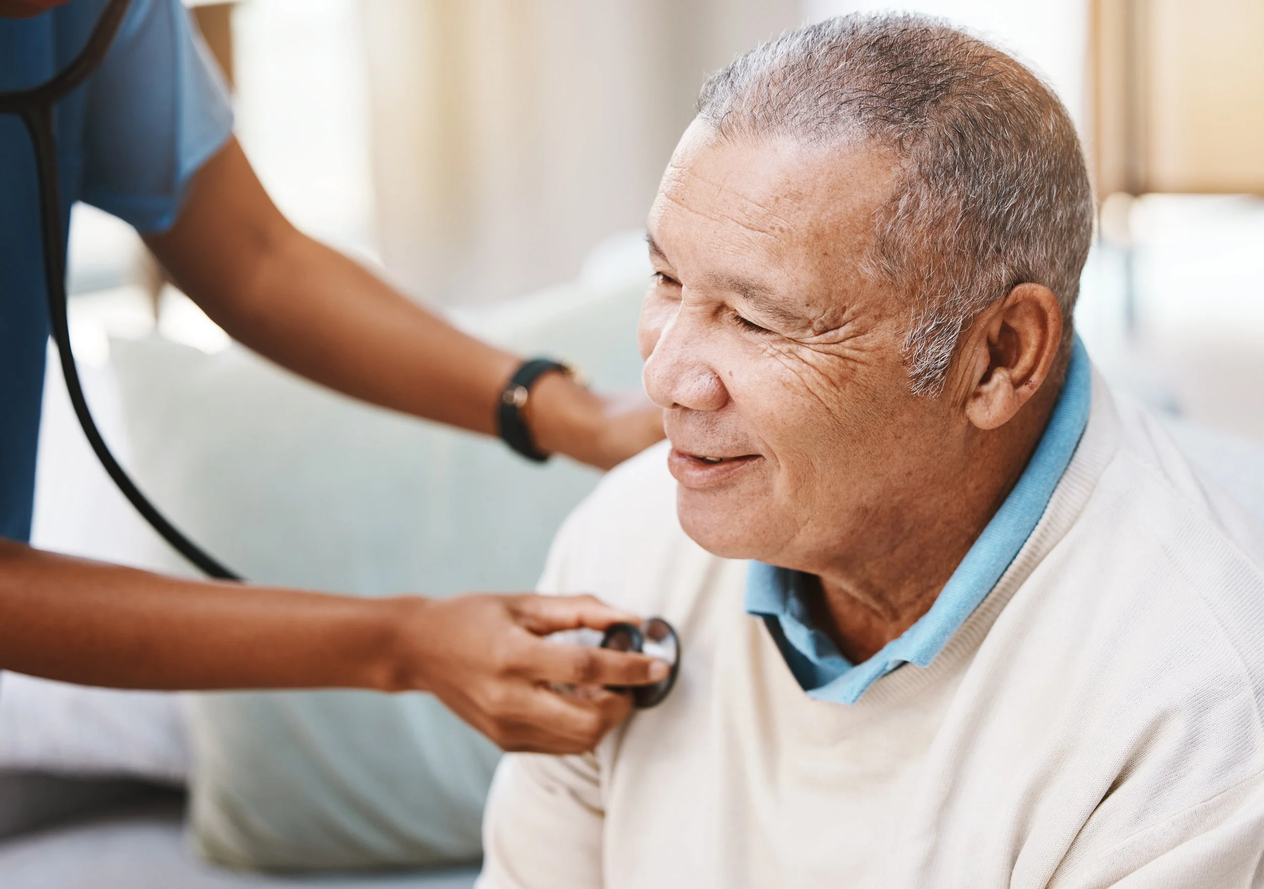 Healthcare professional checking an older adult's blood pressure.