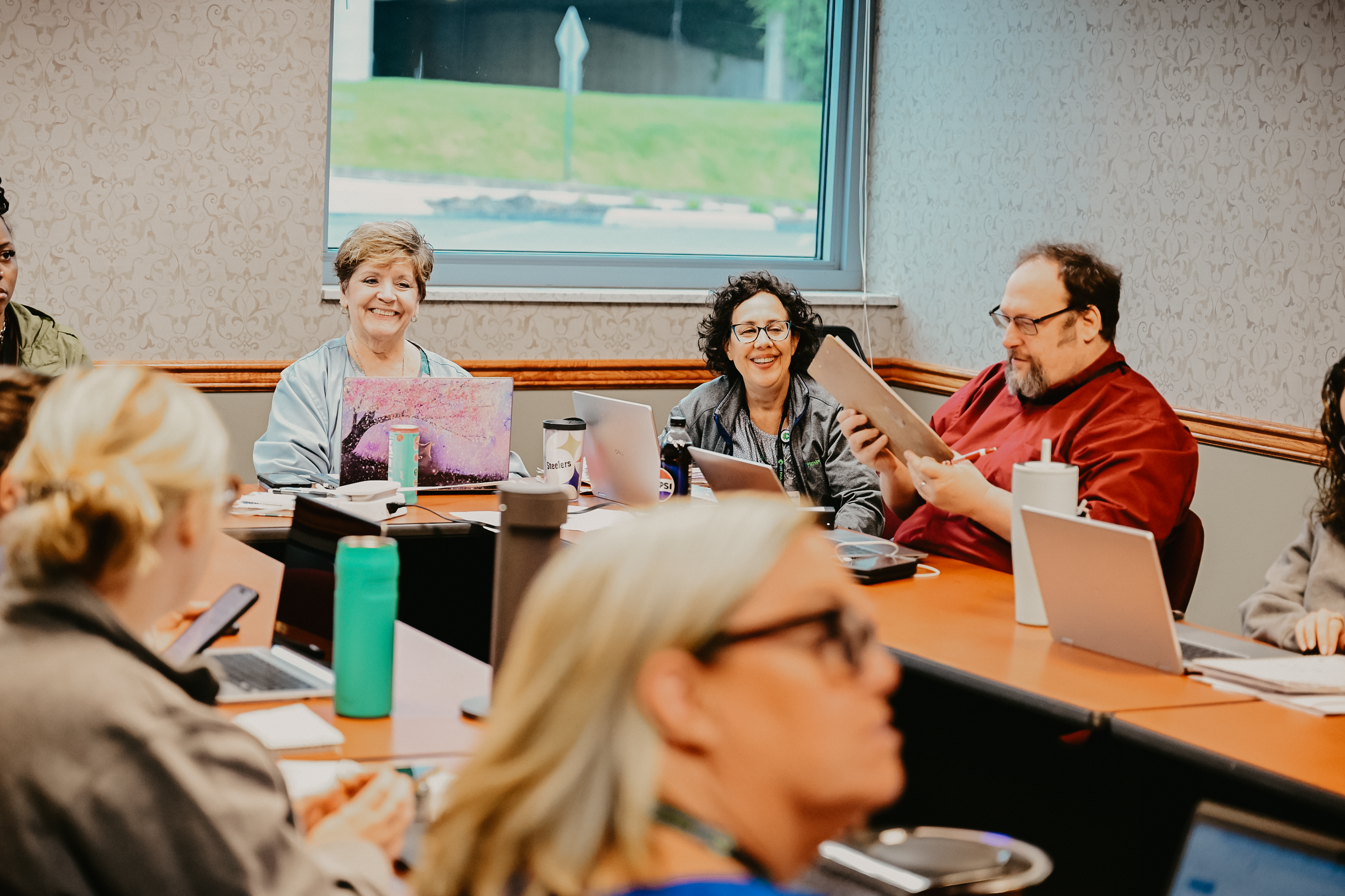 Care team participating in a group meeting / discussion around a table.