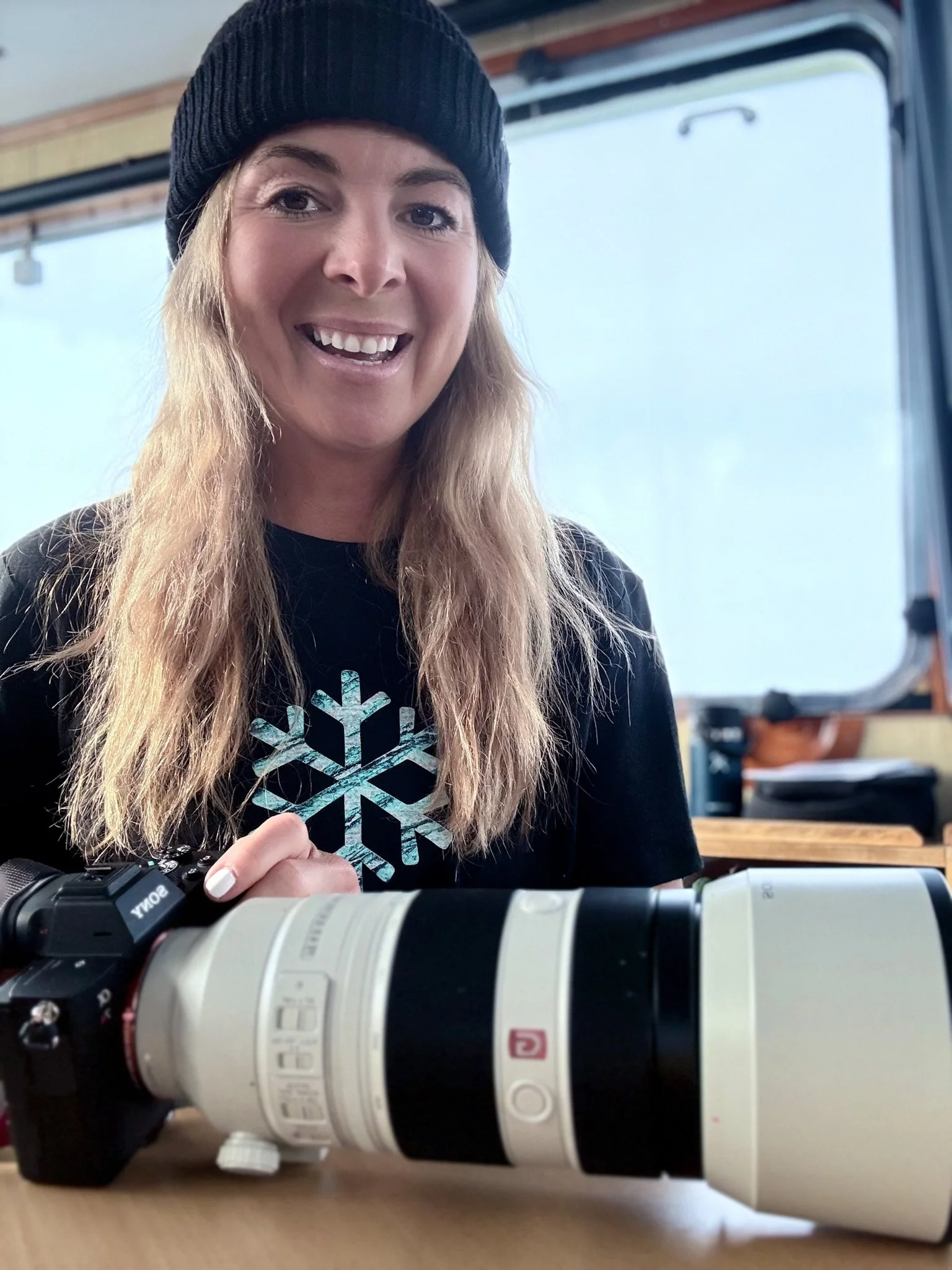 A picture of Alex on an expedition vessel in the Artic with her camera.
