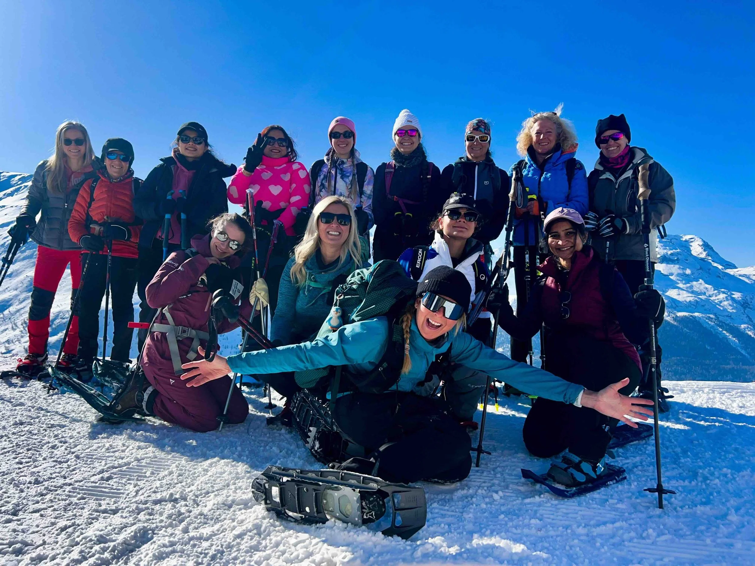 A free snowshoe tour in St. Moritz on International  Women's Day. A group of women and me, Alex in the front, posing on Muottas Muragl in the Swiss Alps the snowshoe tour I organise and lead every year for women.