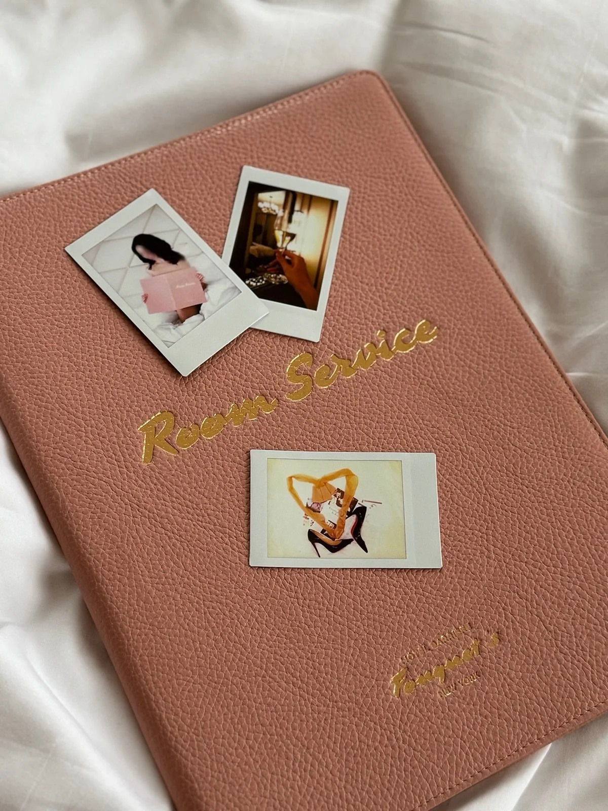 Brunette NYC escort and travel companion, Piper Leigh, has 3 polaroid photos on a pink room service menu from a high end hotel