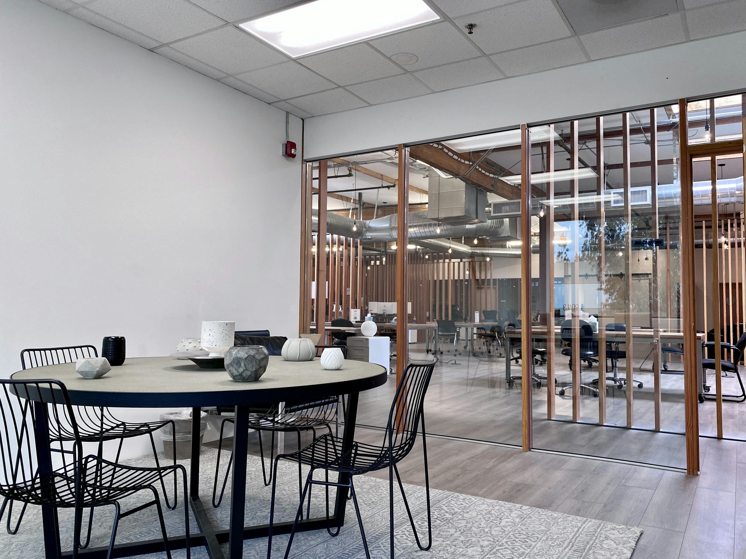 Creative office interior with exposed timber beams and glass-walled conference room in a converted Portland Central Eastside warehouse building