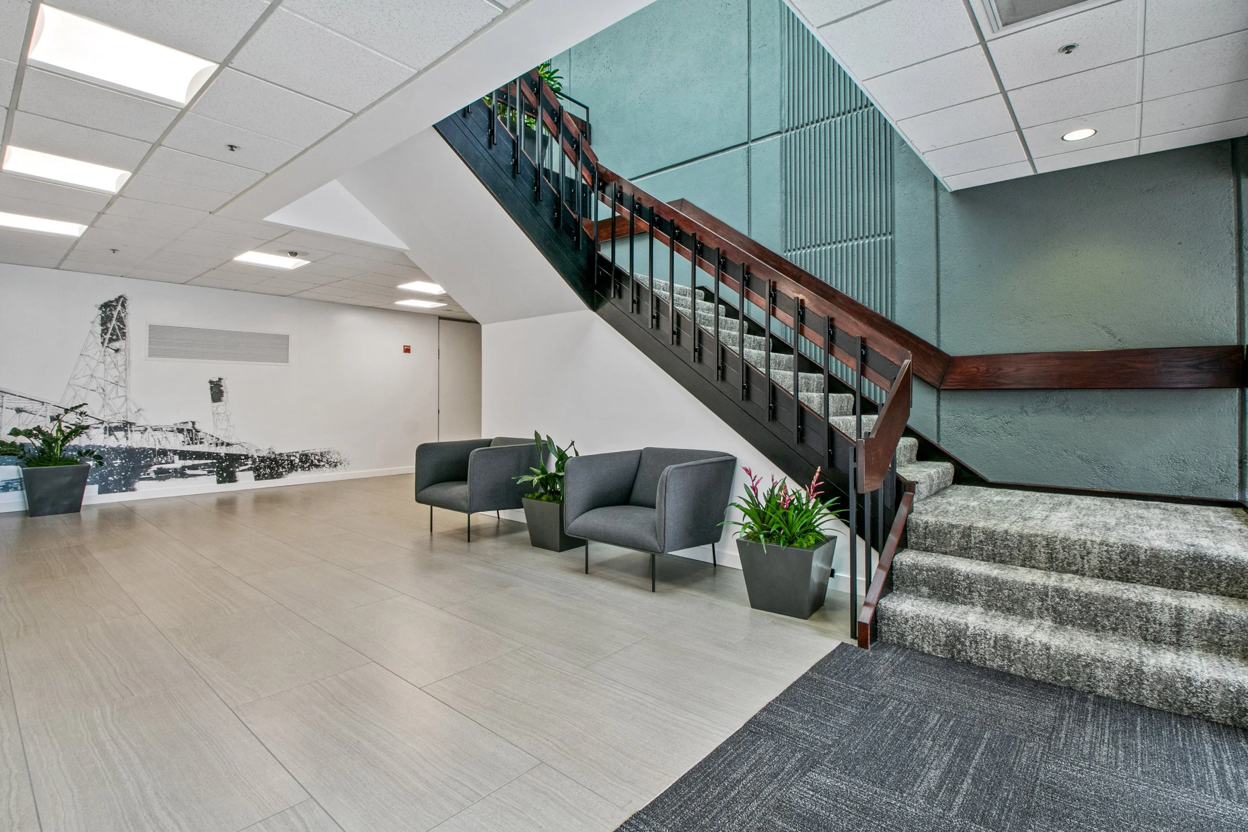 Modern office building lobby at 4000 Kruse Way Place in Lake Oswego, featuring open staircase, contemporary seating area, and recessed lighting