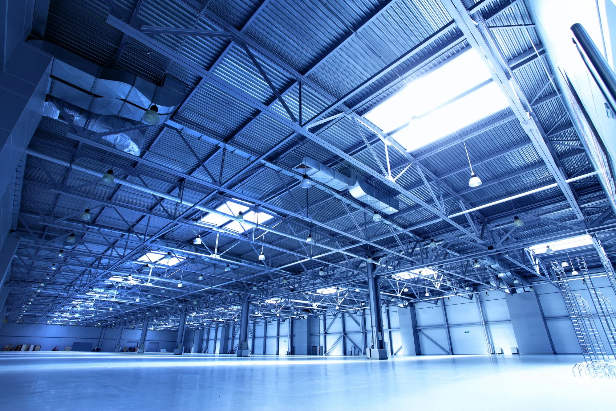 Interior of a large Portland industrial warehouse with steel trusses, high ceilings, and overhead lighting