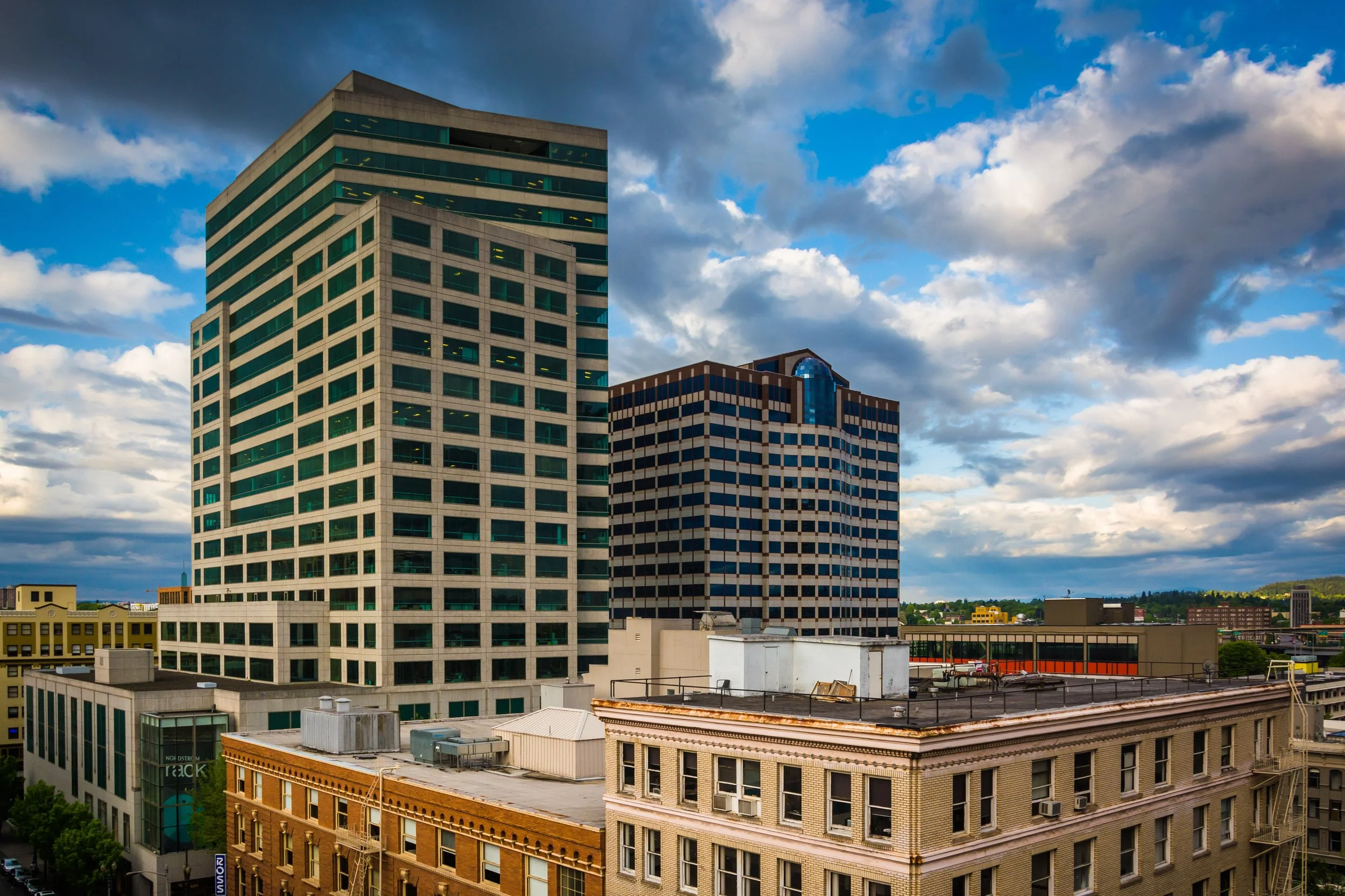 Downtown Portland office tower skyline with commercial high-rise buildings against cloudy sky