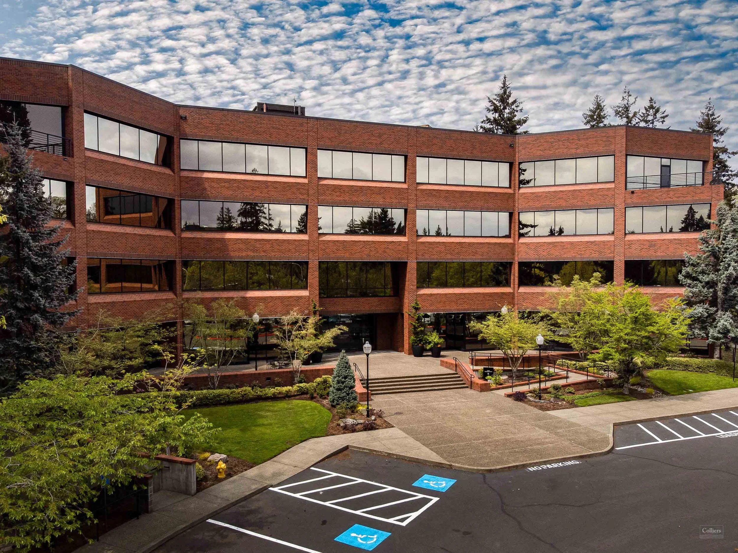 Three-story Class A office building on Kruse Way in Lake Oswego, Oregon, with brick and glass facade and mature landscaping