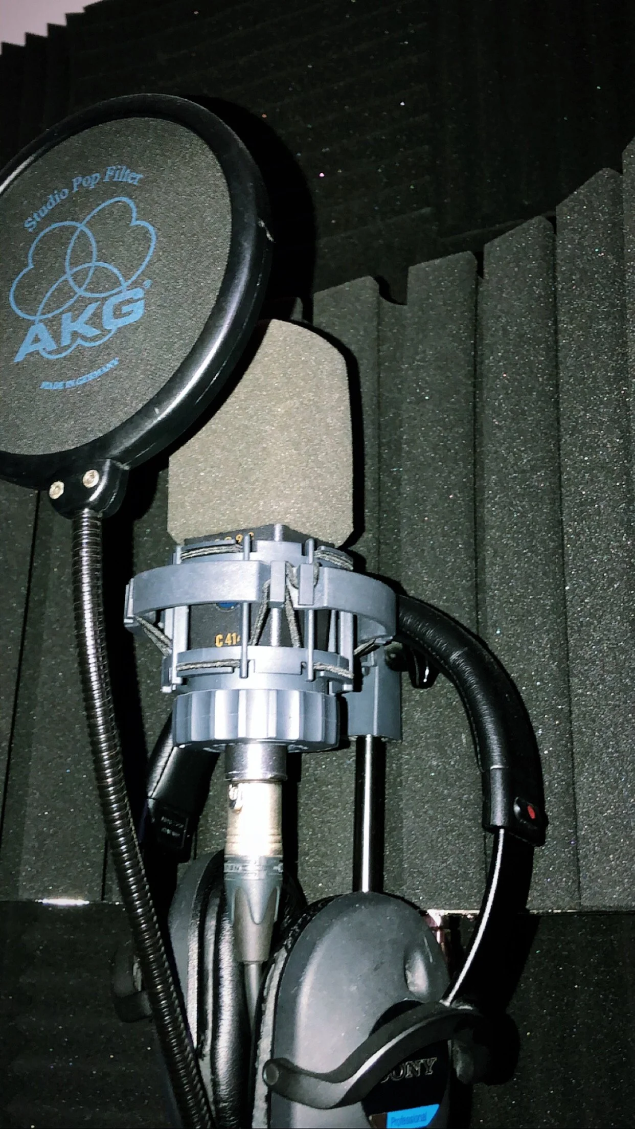 Recording studio microphone and headphones in an audio soundproof booth.