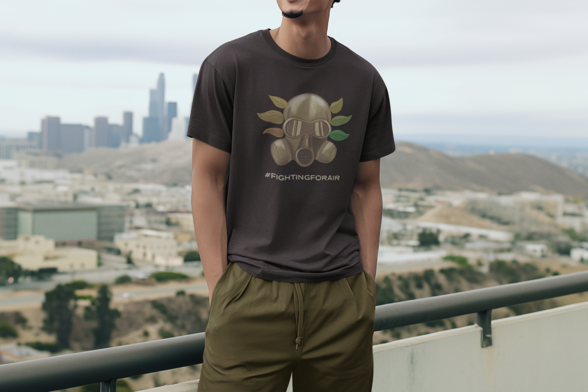 A man wearing a black T-shirt with a graphic of a gas mask and the hashtag #FIGHTINGFORAIR, standing on a balcony with a hazy and solemn cityscape in the background.