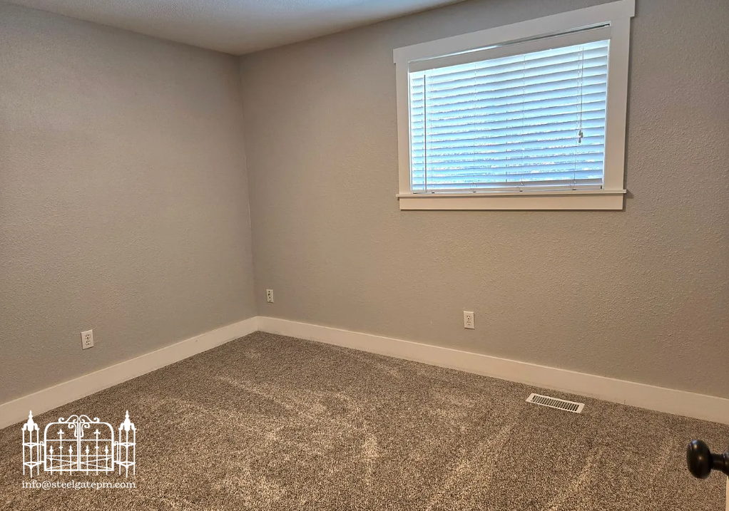 Empty room with beige carpet, light gray walls, a window with blinds, and baseboard heating.