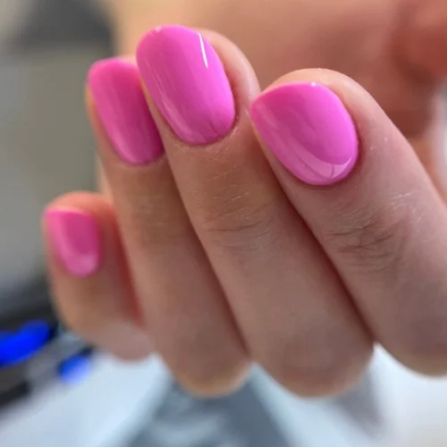 Close-up of a hand with pink painted nails.