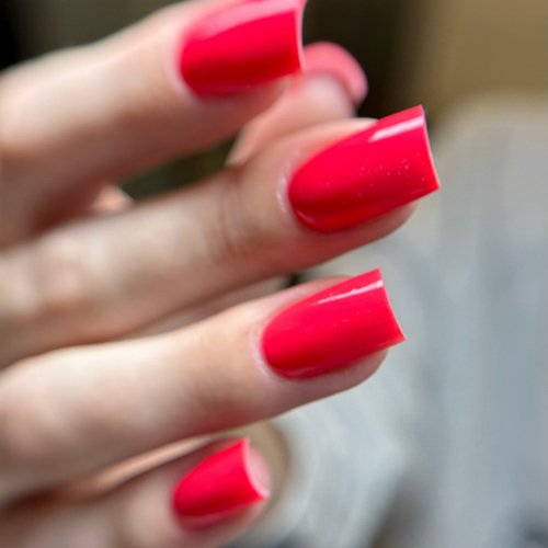 Close-up of fingers with bright red, manicured nails.