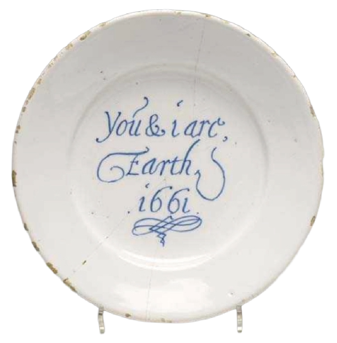 A white ceramic plate with blue handwritten text that says 'You & i are Earth 1661'.
