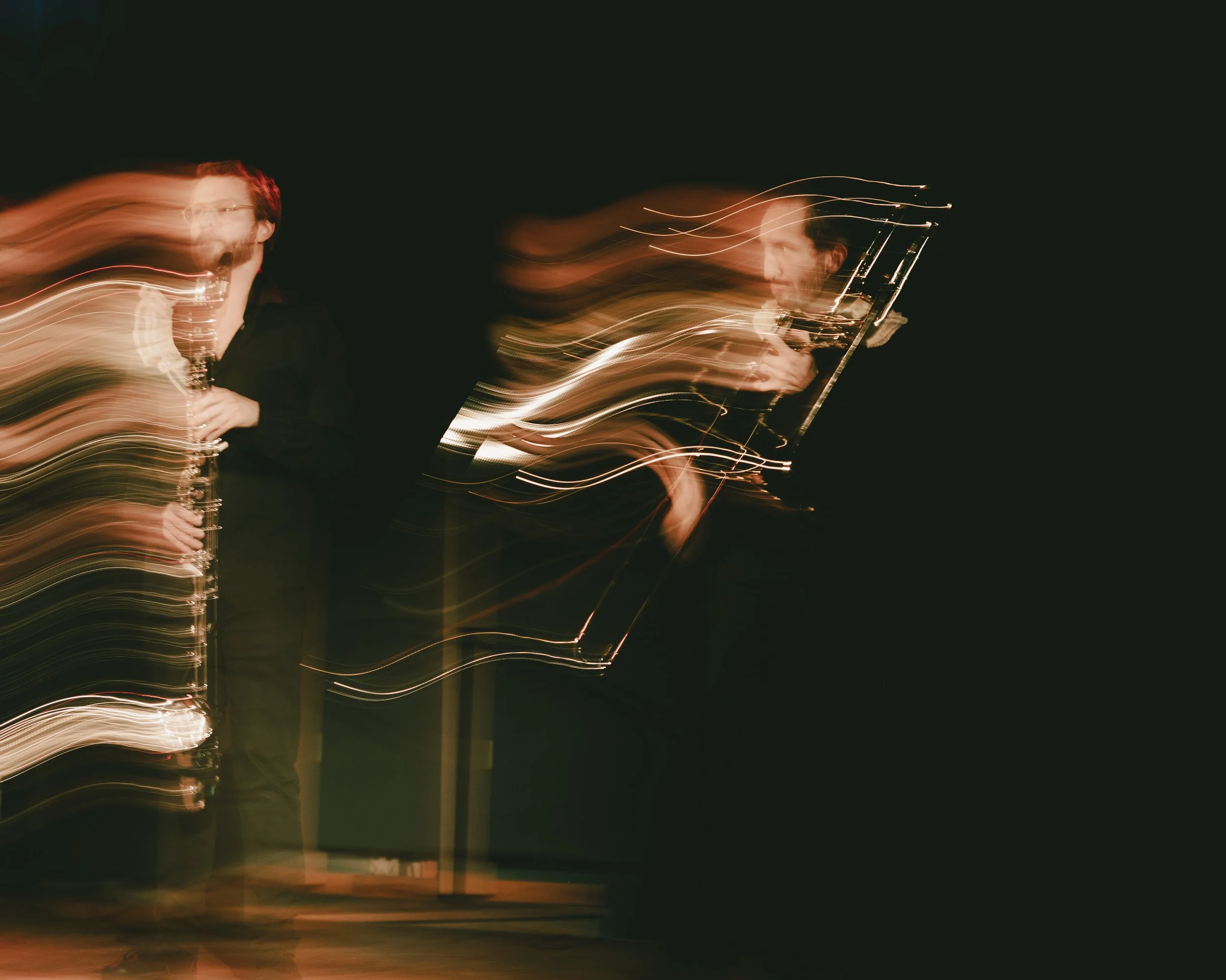 Musiker mit Saxophon auf der Bühne bei Nacht, kreativ verwackelt.