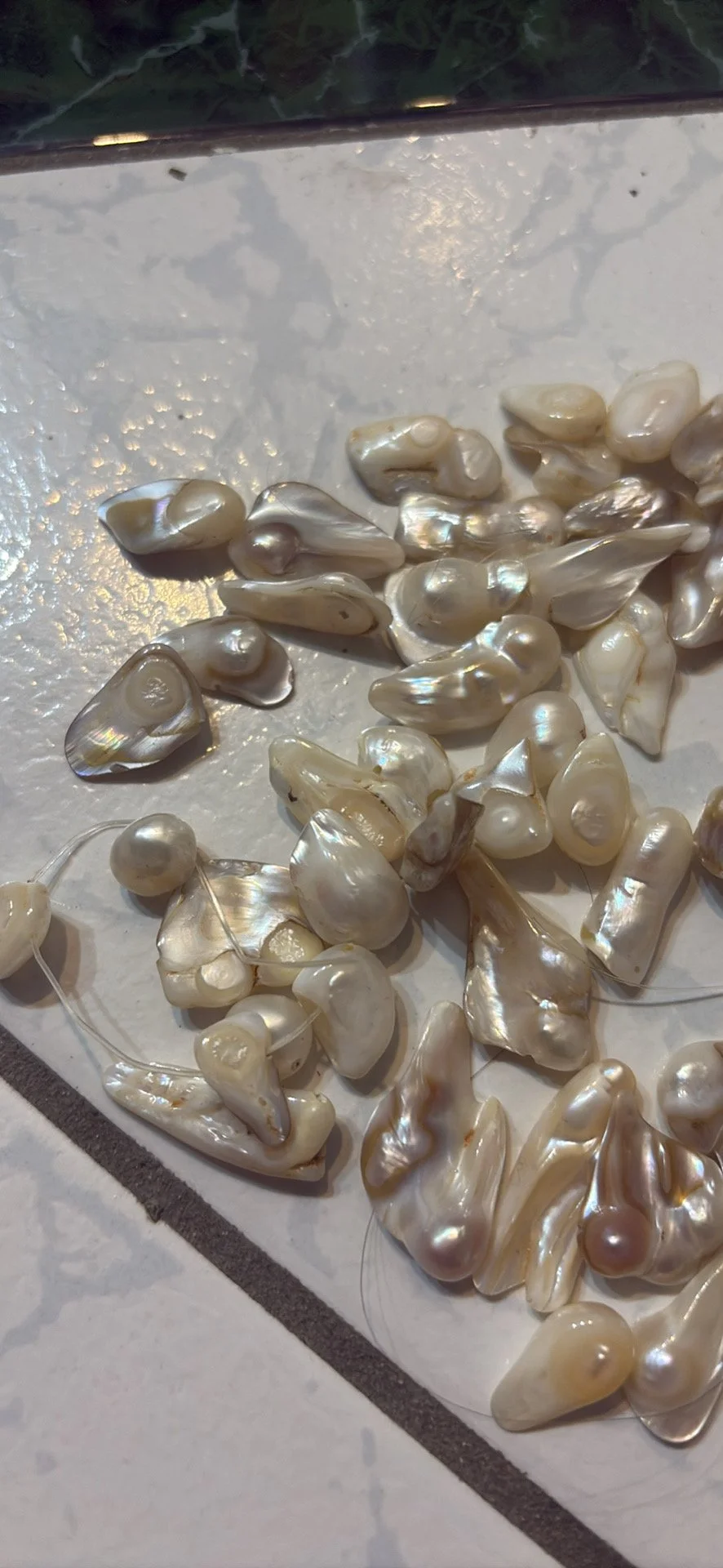 Collection of baroque pearls scattered on a white surface.