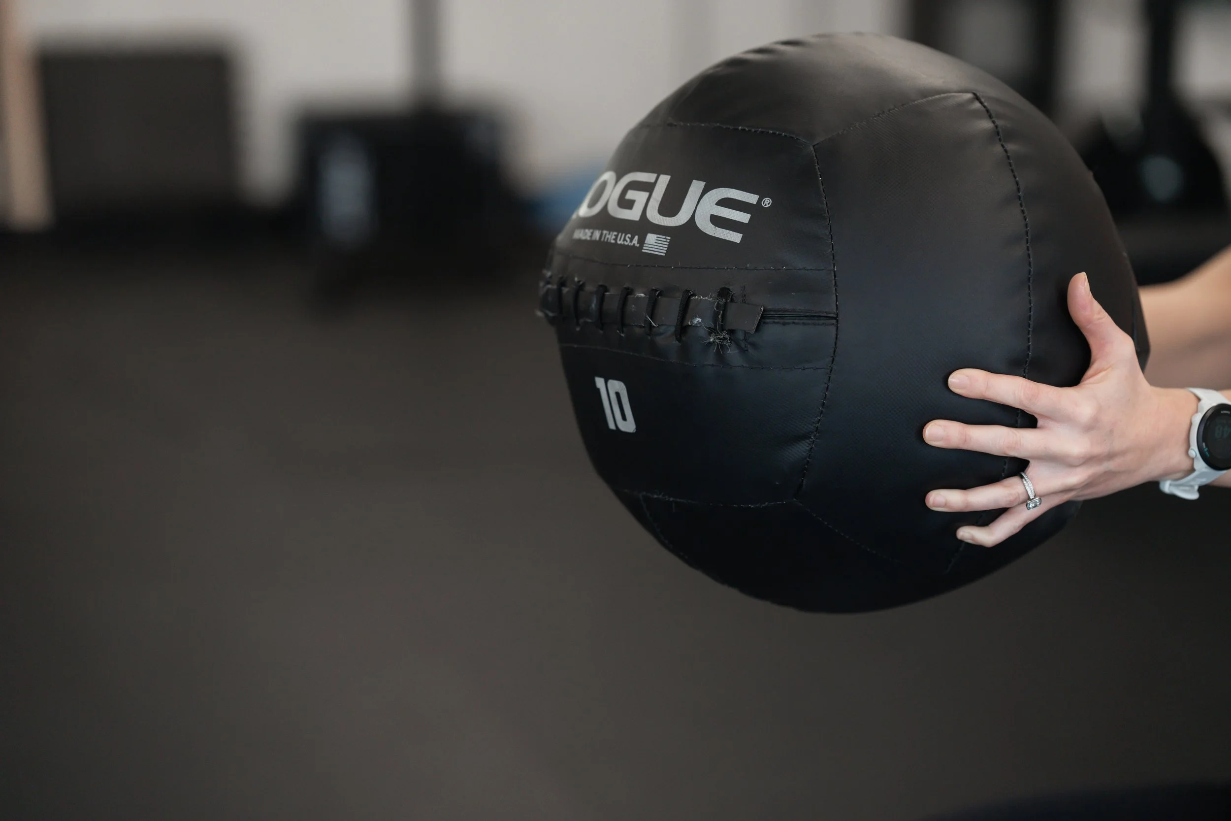 Person holding a black battle rope with the word 'ROGUE' and the number '10' printed on it