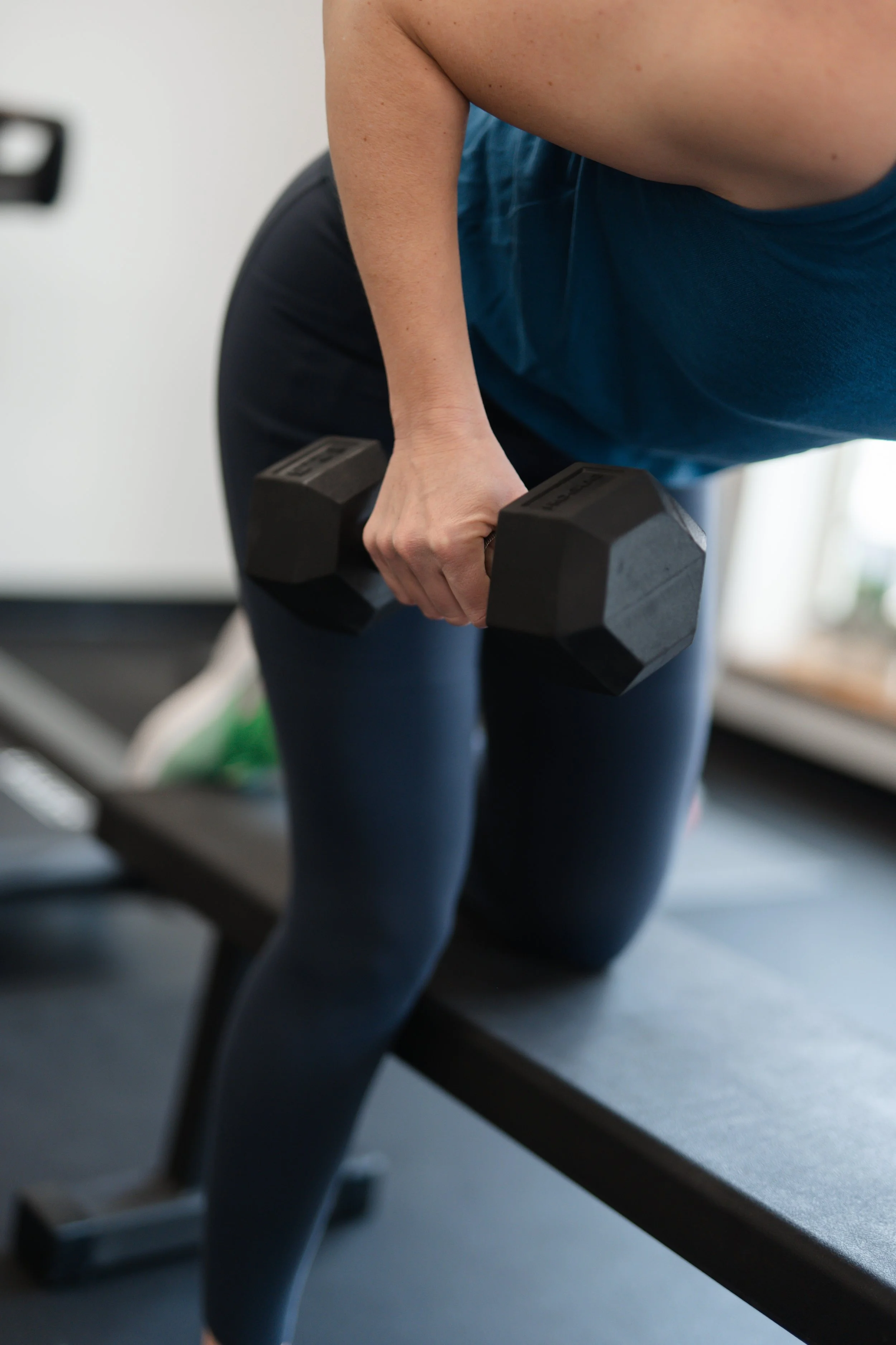 A person performing a workout on a bench, holding a dumbbell in one hand.