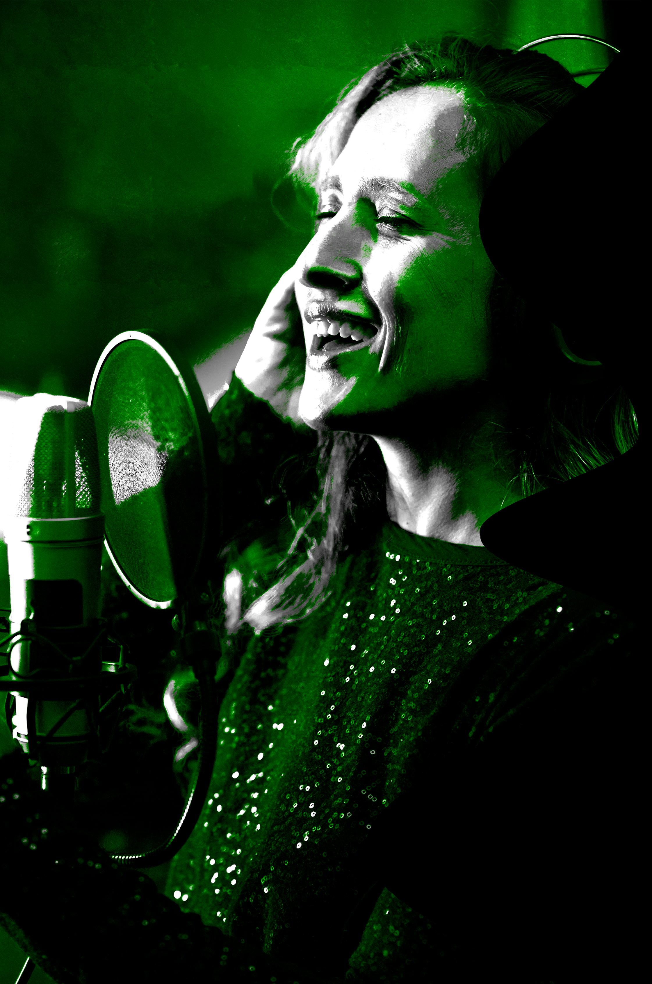 Mulher sorrindo, com cabelo ao ar livre, usando roupas com brilho, em frente a microfone, enquanto canta ou grava uma música.