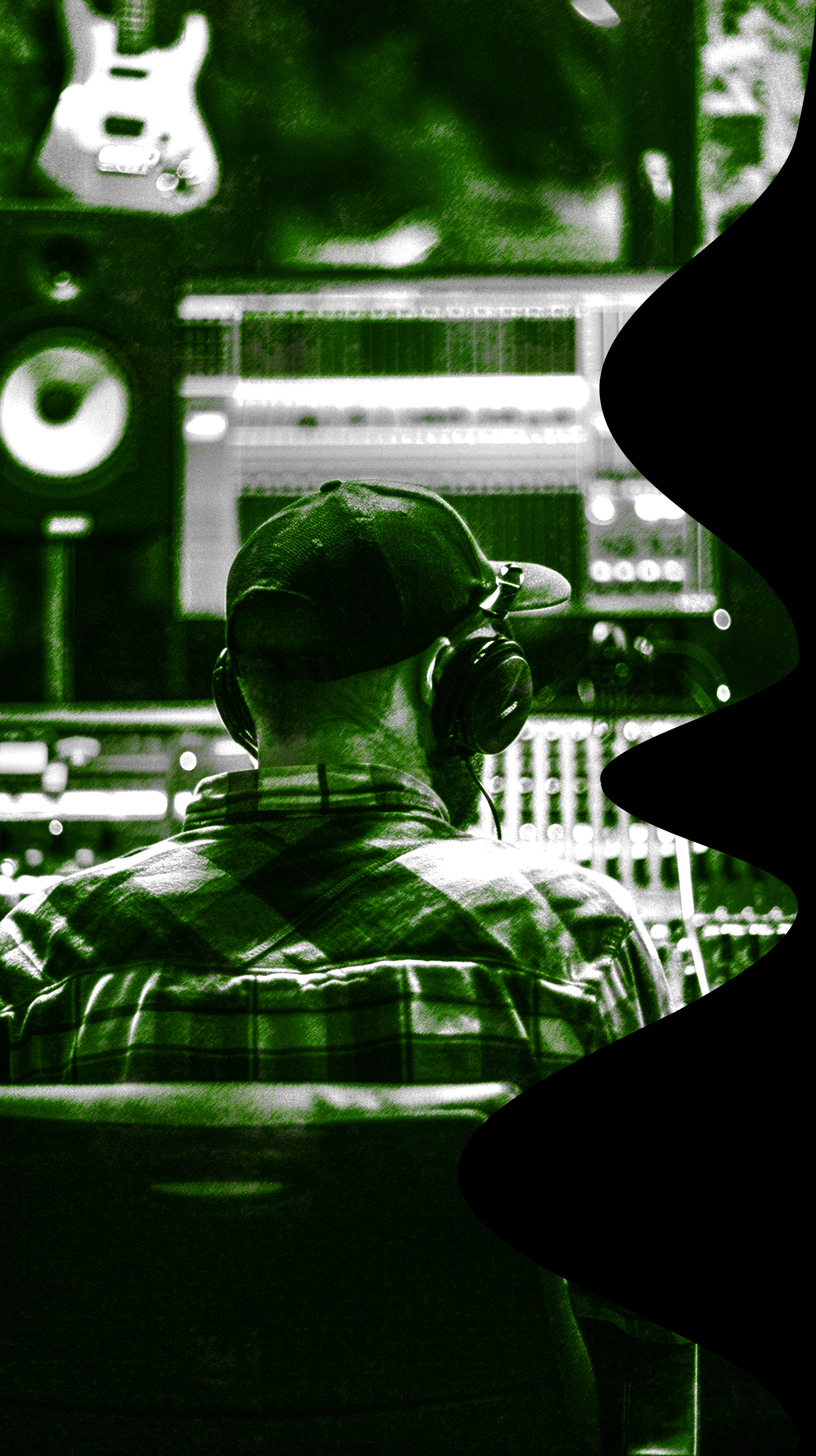 Pessoa assistindo a uma produção musical com fones de ouvido, sentado em uma cadeira, com um computador e equipamento de áudio à sua frente