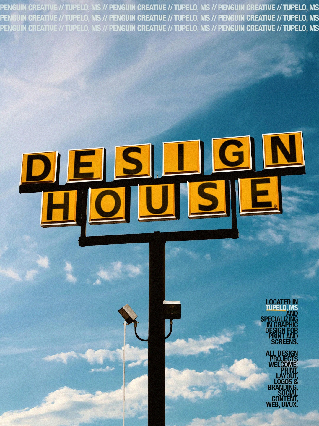 Signboard with yellow and black blocks spelling out 'DESIGN HOUSE' against a blue sky with clouds, advertising graphic design services in Tupelo, MS.