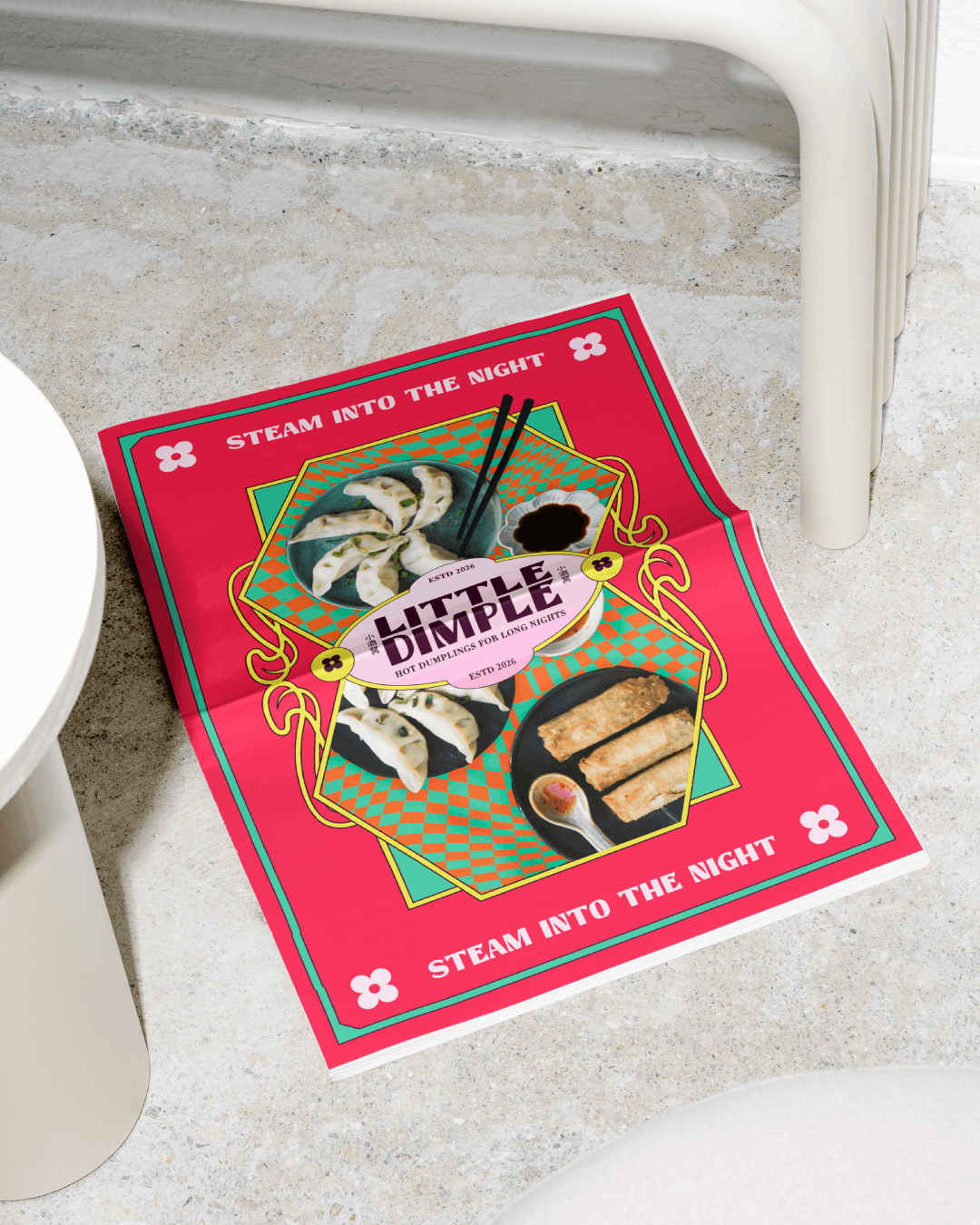 Colorful flyer on the floor featuring images of dumplings and spring rolls, with text that reads 'Steam into the night' and 'Little Dimple, hot dumplings for long nights,' set against a geometric patterned background.
