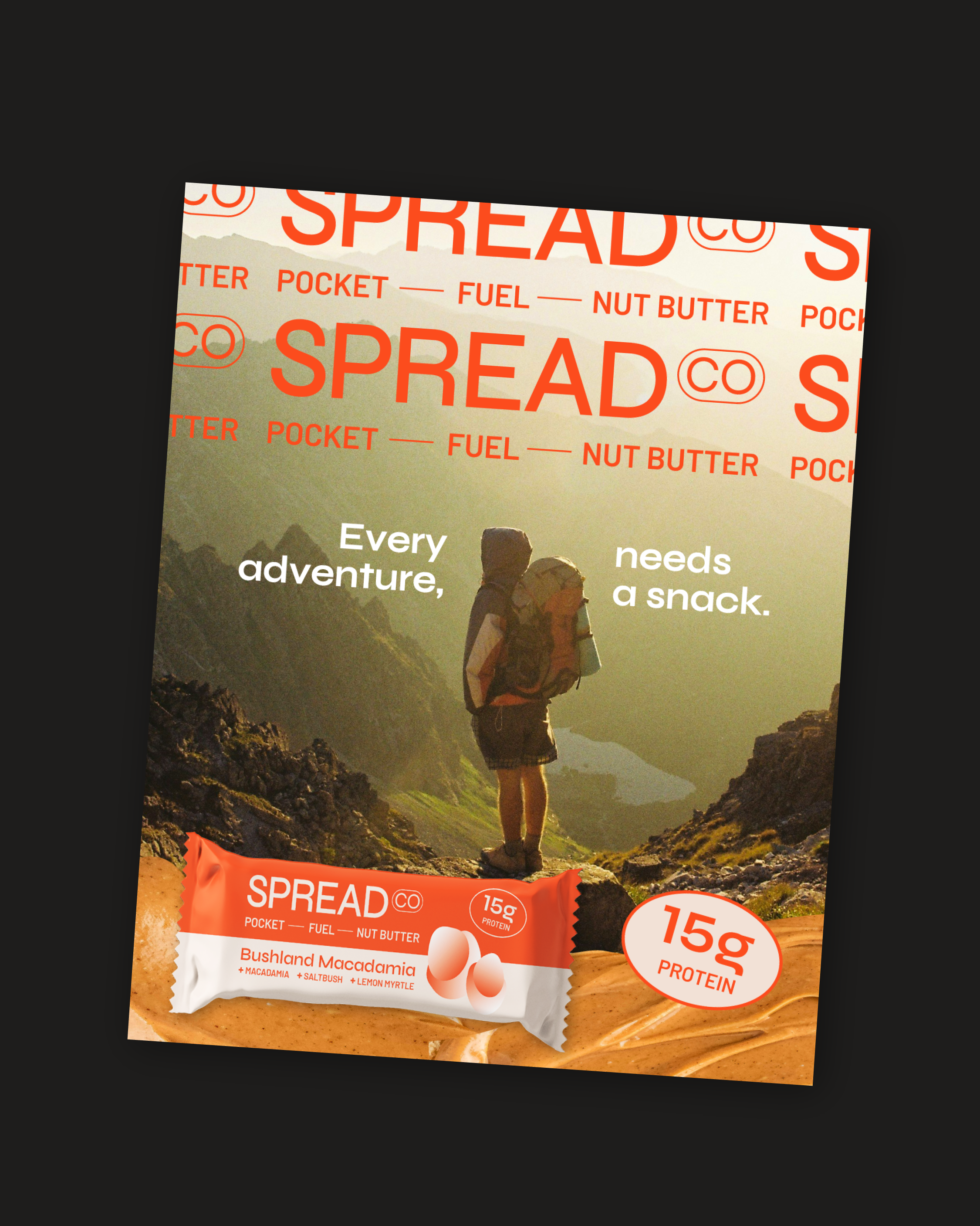 An advertisement for Spready energy snack in a mountain outdoor setting featuring a hiker with a backpack. The package highlights 15 grams of protein and the flavor Bushland Macadamia.