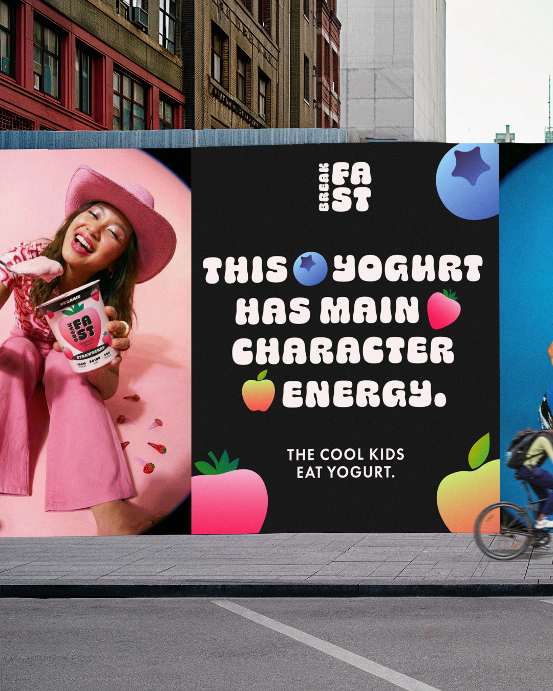Colorful billboard featuring a woman in pink holding a container of strawberry-flavored yogurt with a pink hat. The billboard has playful text about yogurt's main characteristics with fruit illustrations.