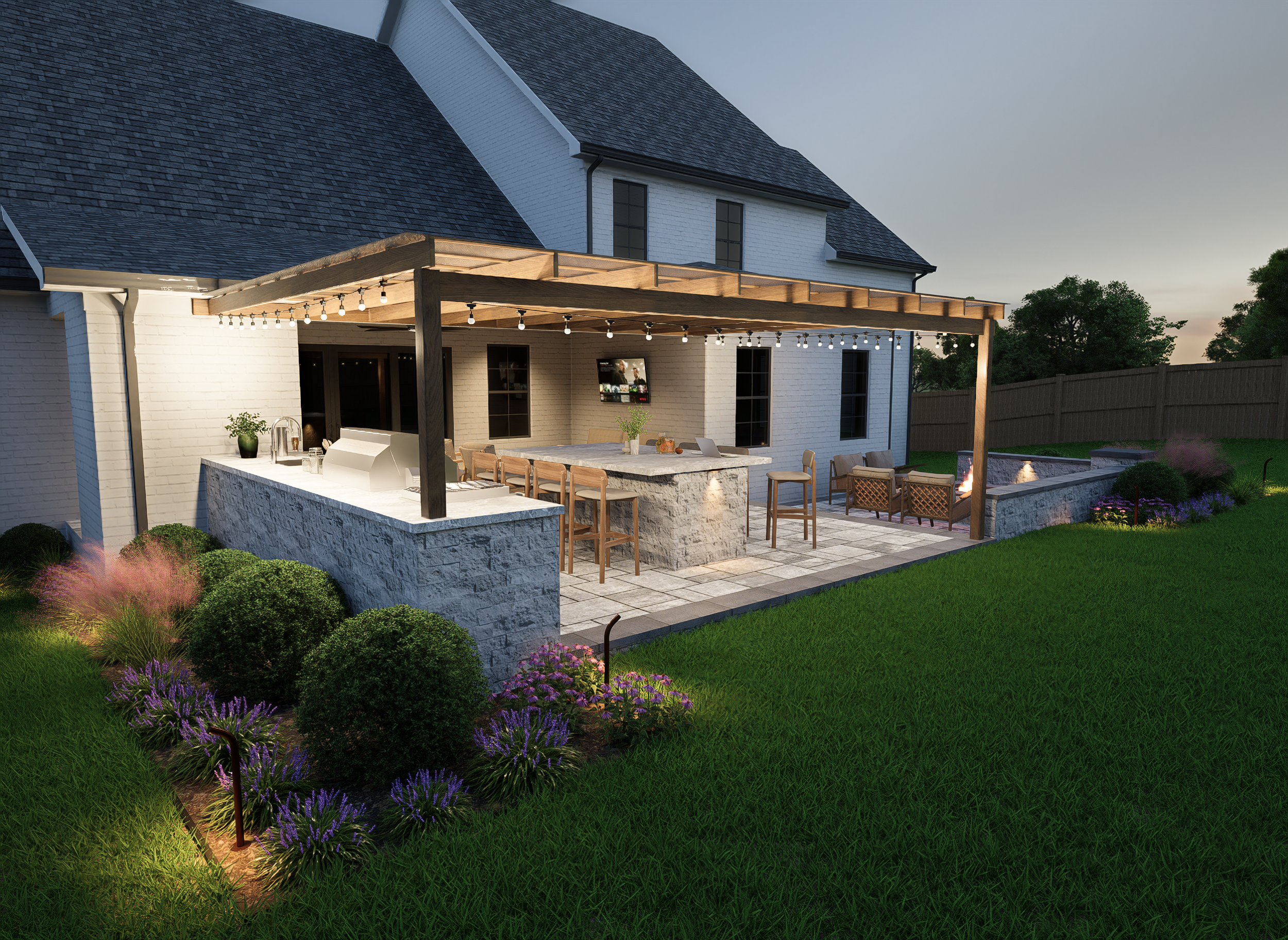 A backyard patio at dusk with a white brick house, a wooden pergola with string lights, an outdoor kitchen island, a fire pit with chairs, green grass, and purple flowering plants.