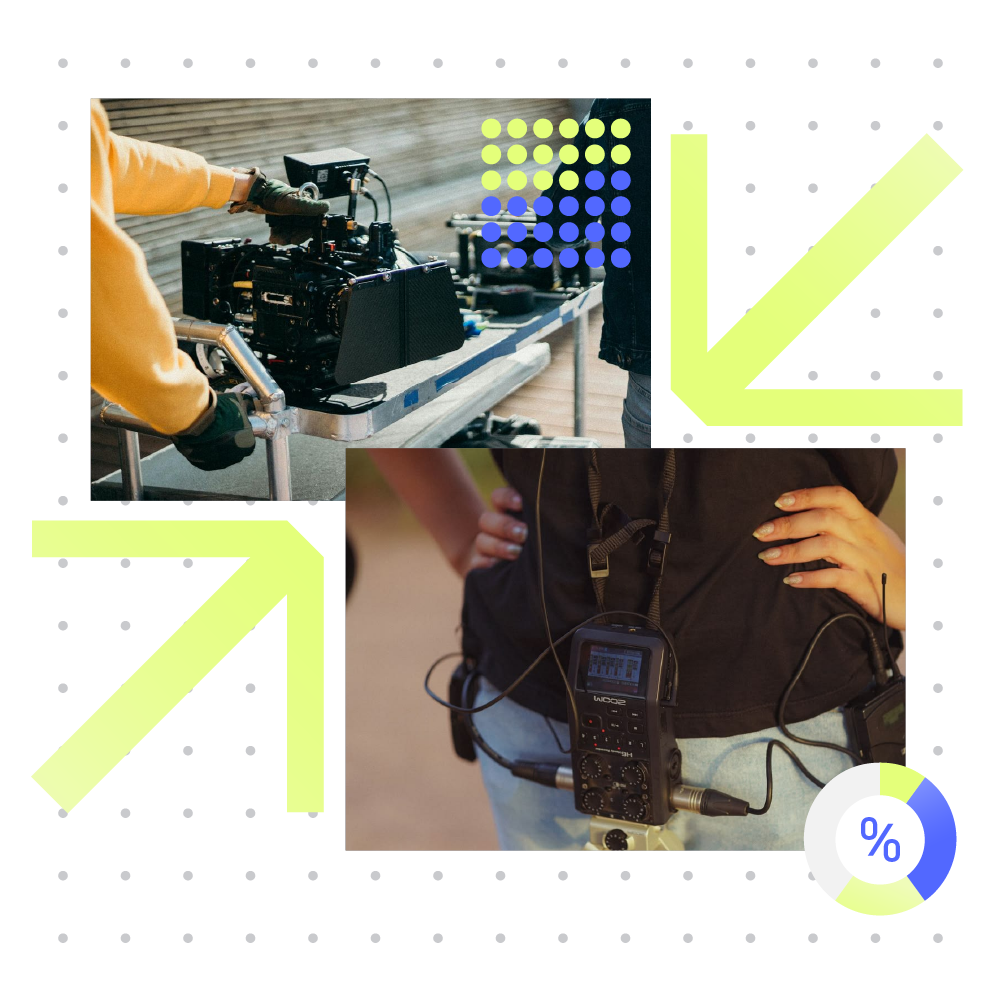 Two people working on film or video production equipment, one with a camera on a wheeled cart and the other with audio recording gear hanging from a lanyard, in an outdoor setting with a background of wooden paneling.