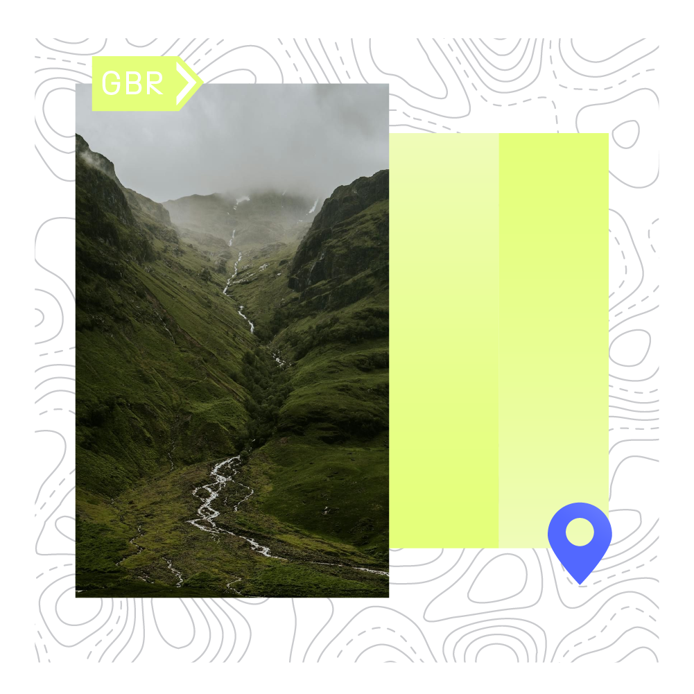 A mountain valley with lush green slopes, small waterfalls, and mist-covered peaks in the distance.