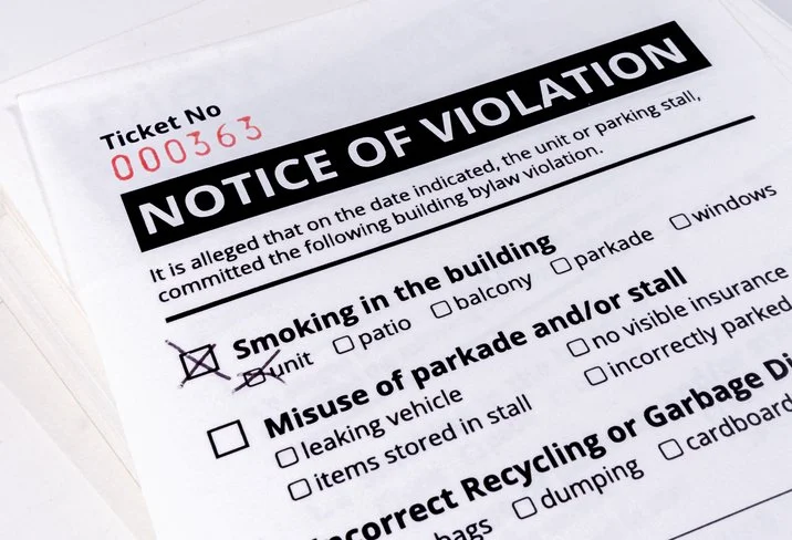 Notice of violation form with ticket number 000363, indicating a smoking violation inside a building with a marked check.