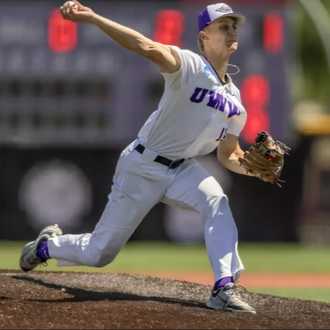 A female softball pitcher in a white uniform with purple accents, throwing a pitch on a softball field.