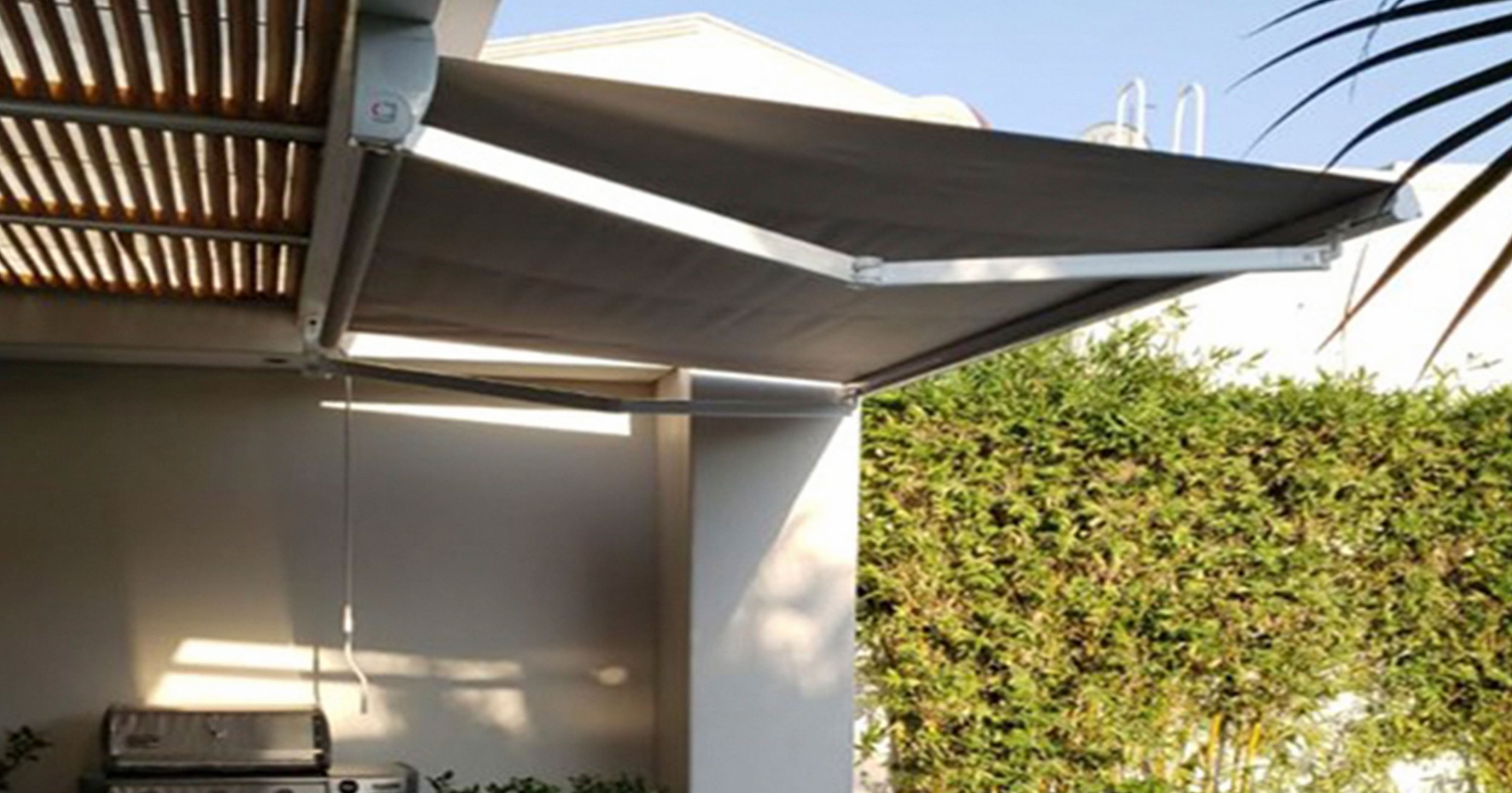 Toldo retráctil Decotech para reducción de calor y protección UV en áreas de alberca y jardín en Querétaro.