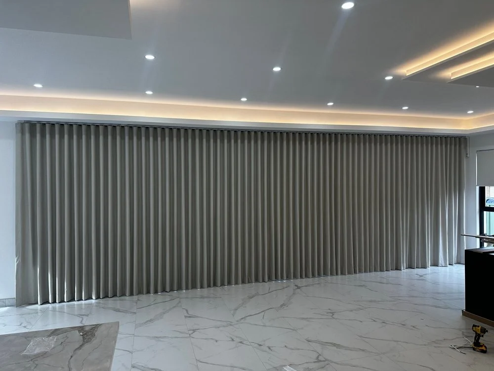 Cortinas blackout térmicas de tela con confección estilo Wave Fold (onda perfecta) instaladas en ventanales de Querétaro