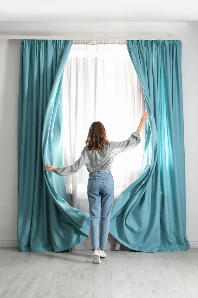 Mujer controlando cortinas automatizadas mediante aplicación móvil en residencia de Querétaro, instalación de Decotech.