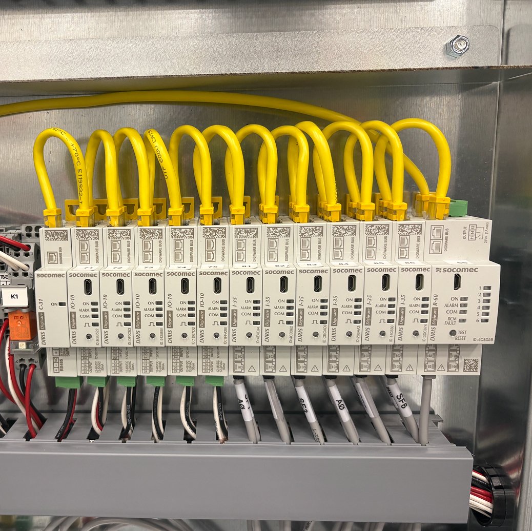 Electrical control panel with multiple connected devices, wires, and yellow cables.