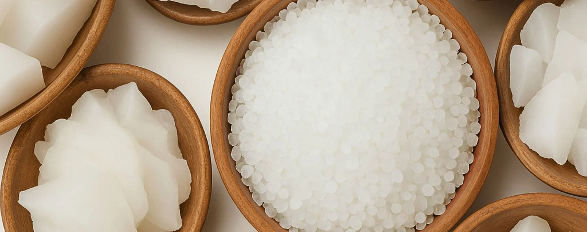 Assorted chunks of white soap in wooden bowls.