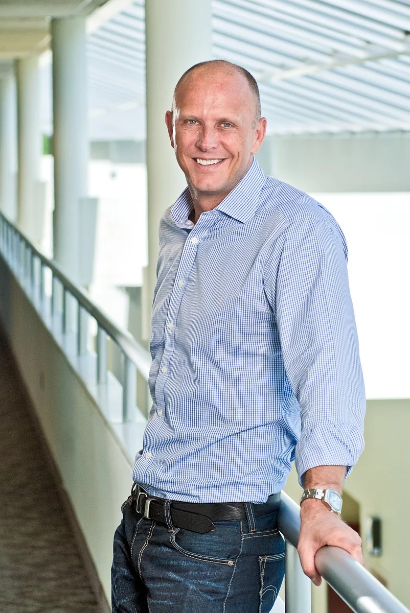 A pharmaceutical company executive poses in the office atrium.