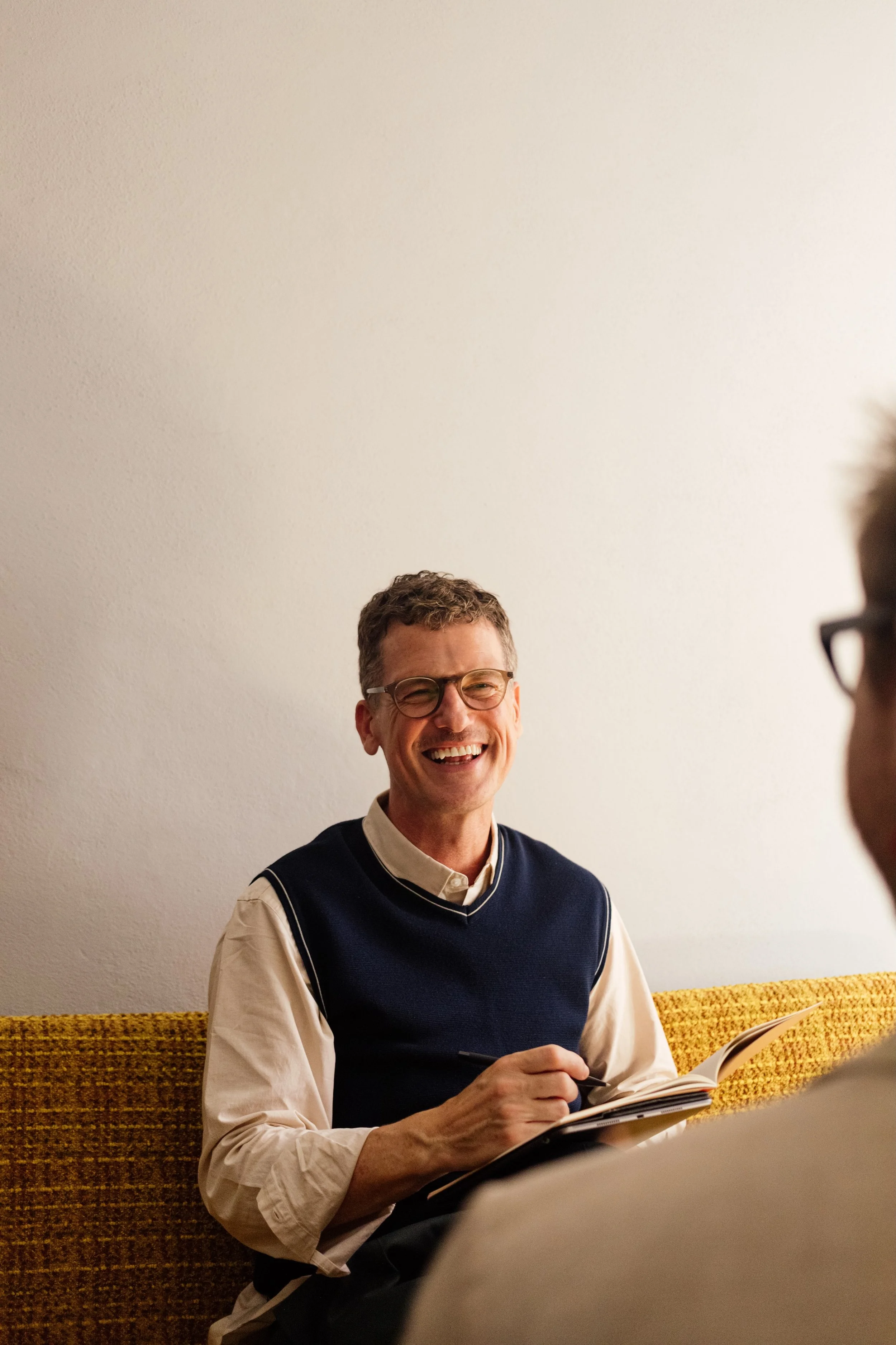 Professional portrait of test prep founder smiling at the camera with a notebook in hand.