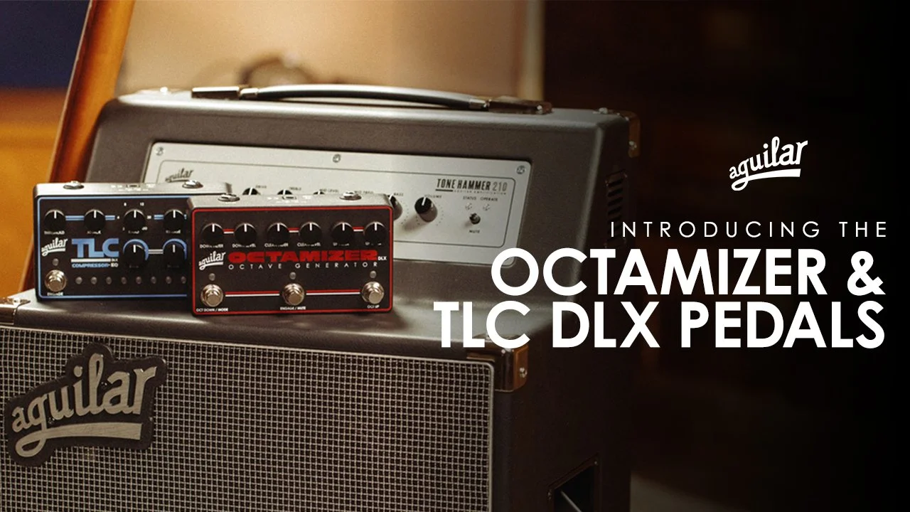 Two guitar effects pedals, a compressor and an octave generator, placed on top of an amplifier, with a guitar amplifier and speaker cabinet in the background. The pedals are labeled TLC and Getamizer.