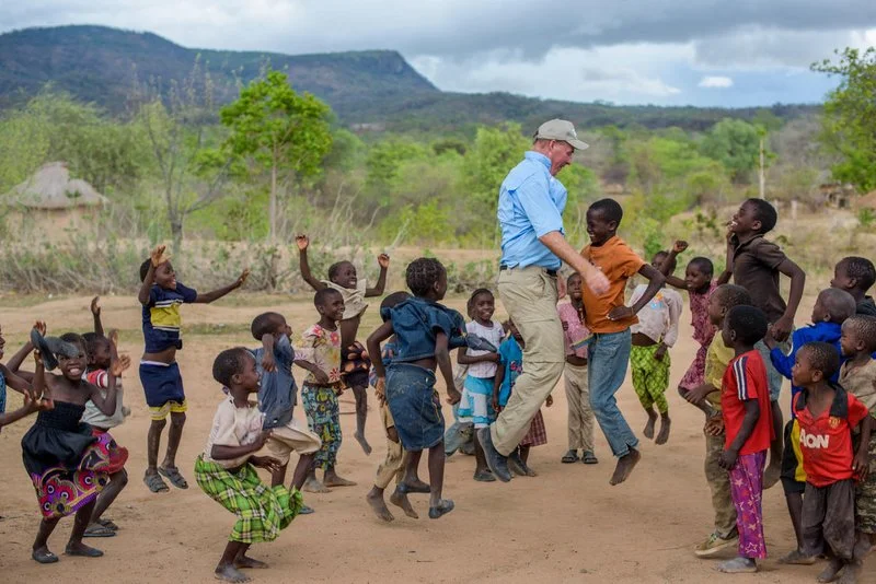 Greg playing a jumping game with children in Zambia