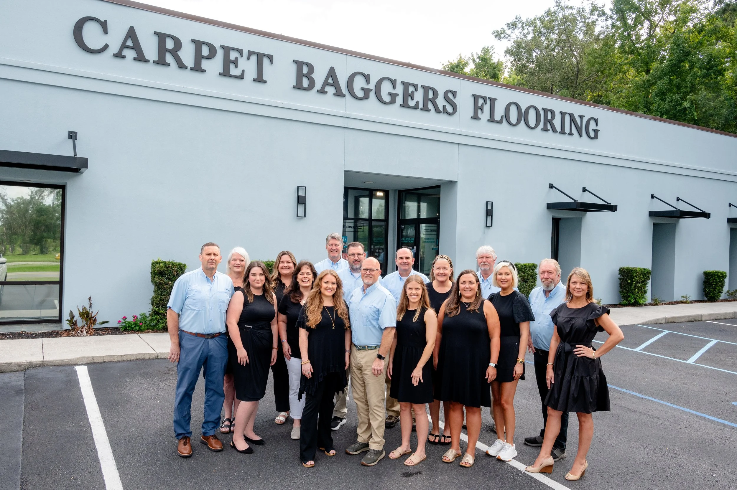 Group of people standing in front of Carpet Baggers Flooring store
