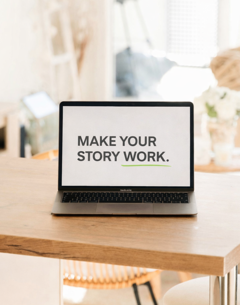 Laptop displaying “Make Your Story Work” brand messaging on a minimalist workspace