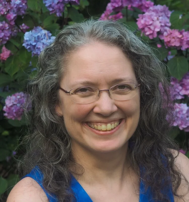 Person smiling in front of hydrangea flowers