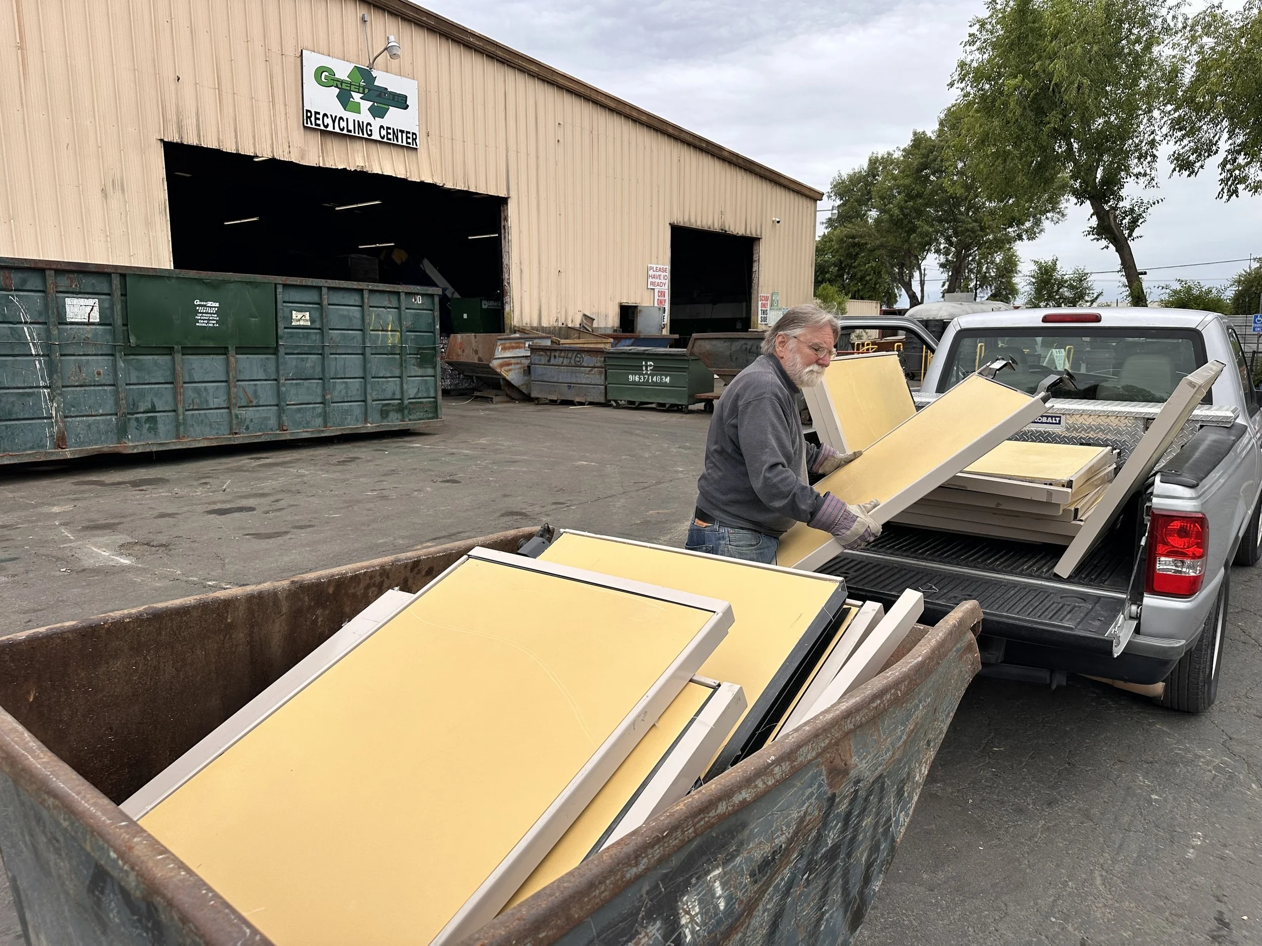 Man unloading cubicle panels for recycling at a Woodland, CA recycling center during EnKore Theatre Company build-out.