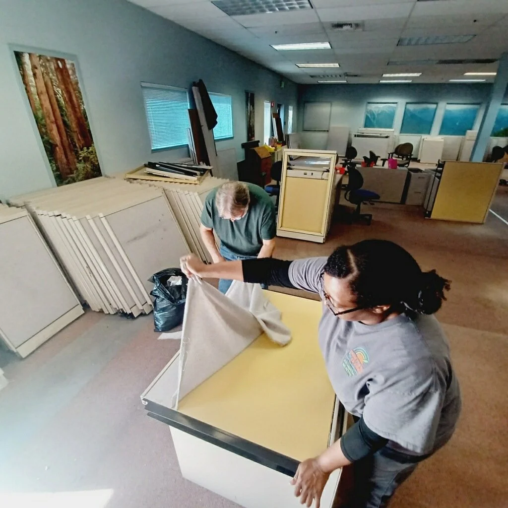 Team members dismantling office cubicles for recycling during theatre build-out at EnKore Theatre Company in Woodland, CA.