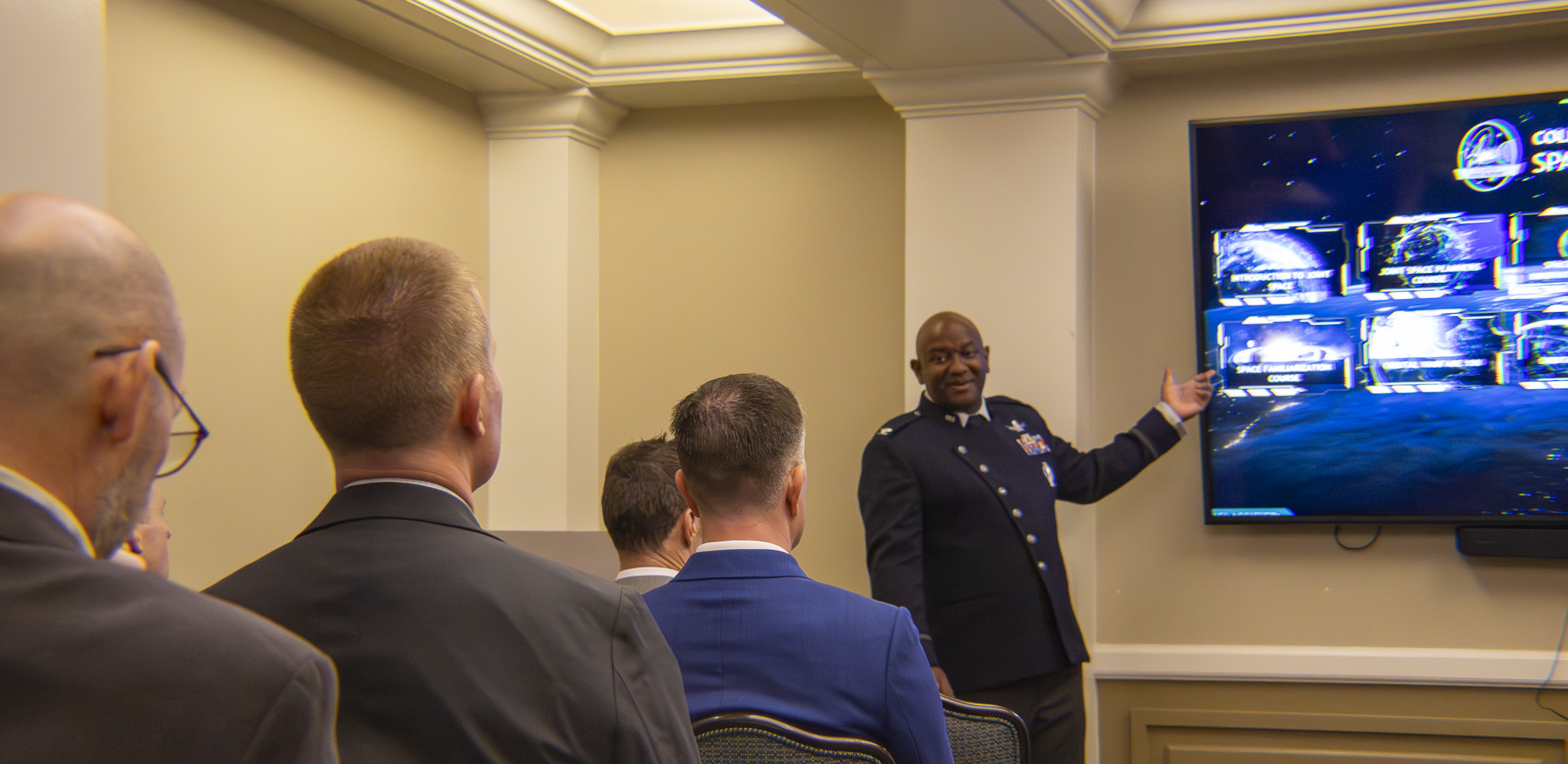 NSSI Col harris addressing a room in front of a screen