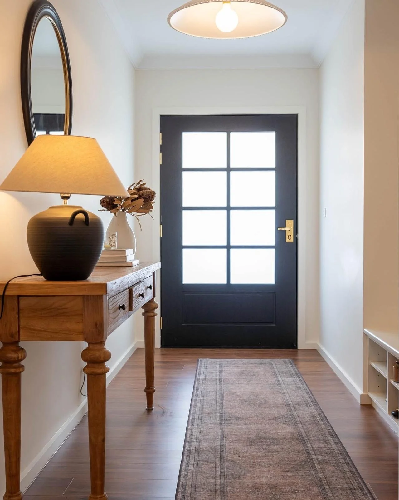 Freshly painted entryway with black front door, completed with professional plastering and interior painting services.