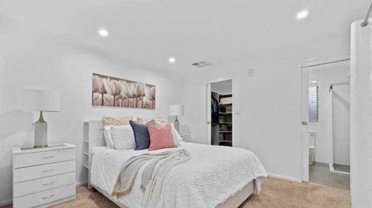 White bedroom restored after water damage repair, including professional plastering and painting services in Canberra ACT.