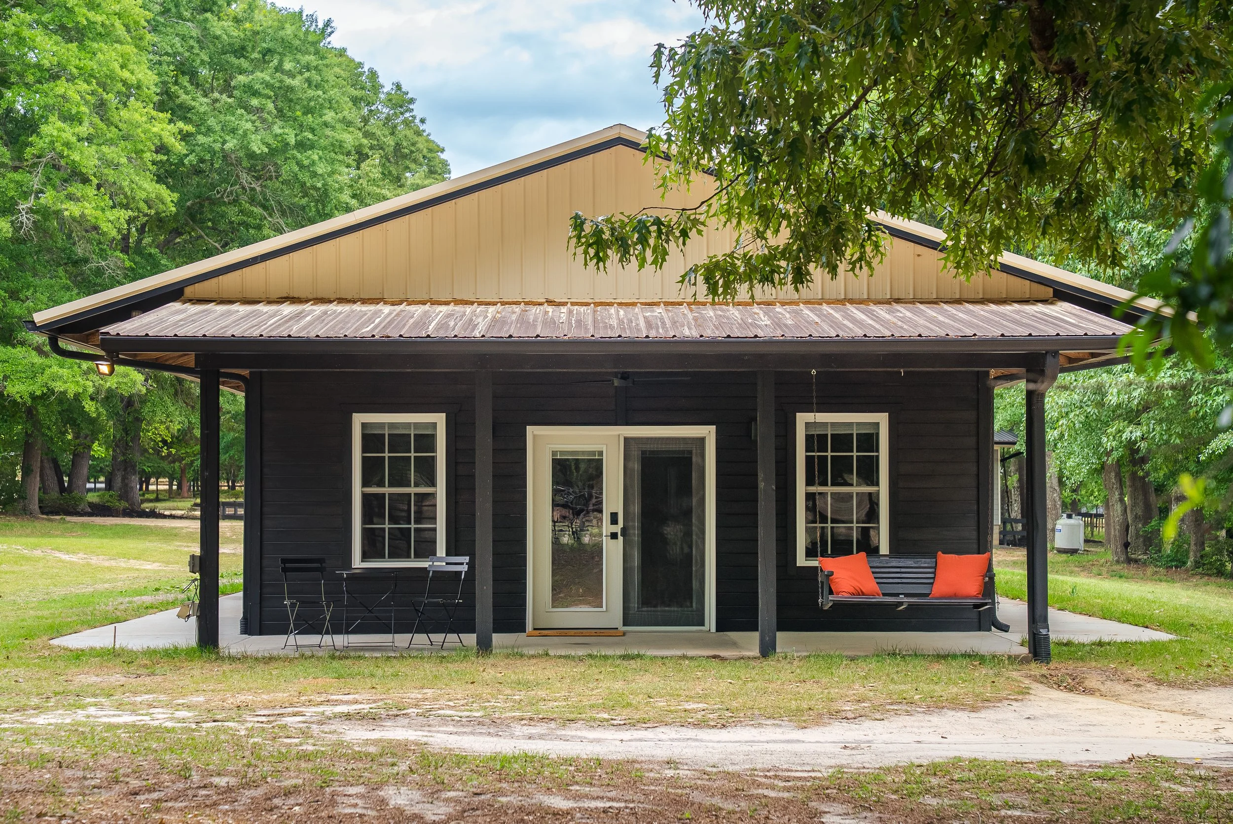 Private entrance and porch with a porch swing and dining area.